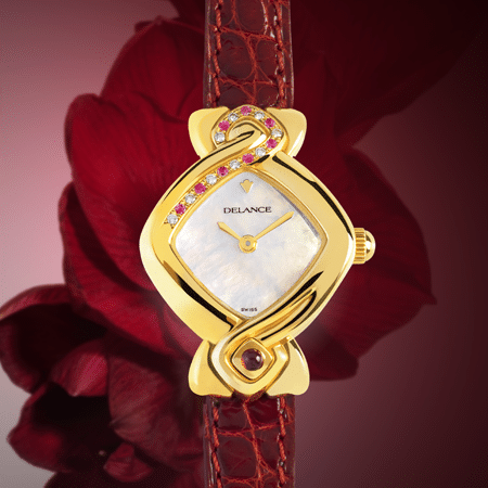 Griha Laxmi : Montre en or sertie de 9 diamants et 8 saphirs roses, cadran nacre blanche, aiguilles dorées, cabochon en or avec un rubis, bracelet en alligator rouge