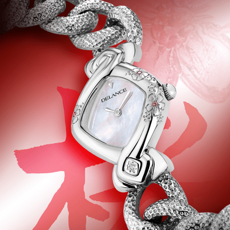 Kanon acier : Montre en acier sertie de 3 fleurs gravées avec un cœur de saphir rose, cadran nacre blanche, cabochon en acier avec un diamant à 6h, bracelet en gourmette