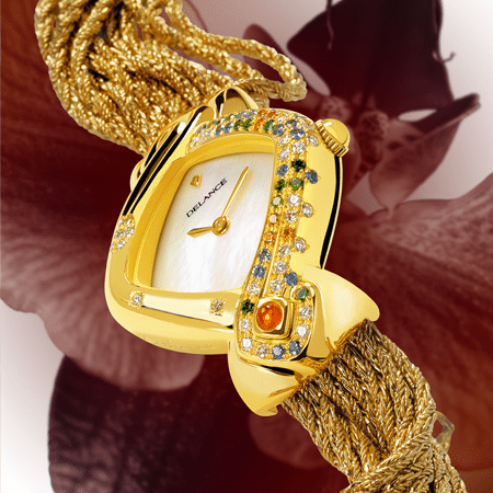 Pour ses soixante ans, Rina s’est offert une montre DELANCE "Secret" très symbolique. Une montre qu'elle porte comme un bijou symbolique. Les pierres semées à l’est, le futur, 6 oranges + 12 vertes + 18 bleues + 24 blanches, lui rappellent que dans son cœur vit toujours la petite fille créative de 6 ans, la jeune fille pleine d’espoir de 12 ans, la jeune femme idéaliste de 18 ans et la femme enthousiaste de 24 ans. Elle est toutes ces femmes qu'elle fut et bien plus encore. Et parce que mère elle le restera toujours, deux pierres précieuses sont serties à l'heure de naissance de ses enfants.
