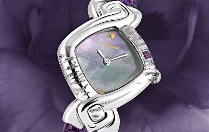 Elle la voulait toute de violet et c’est ainsi qu’elle l’a gravée et sertie d’une améthyste. Pour répondre à la pierre nous avons parée la montre d’un cadran de nacre aux reflets mauves et d’un bracelet en lézard violet. Subtile et délicate, la montre DELANCE « Violet » s’harmonise en tout temps à la personne qui la porte.